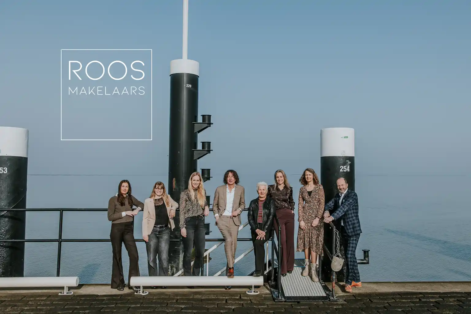 Advertentie van Roos Makelaars met het team op een steiger